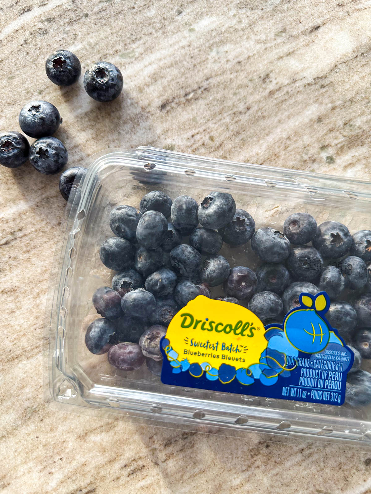 A gray countertop with a carton of blueberries.