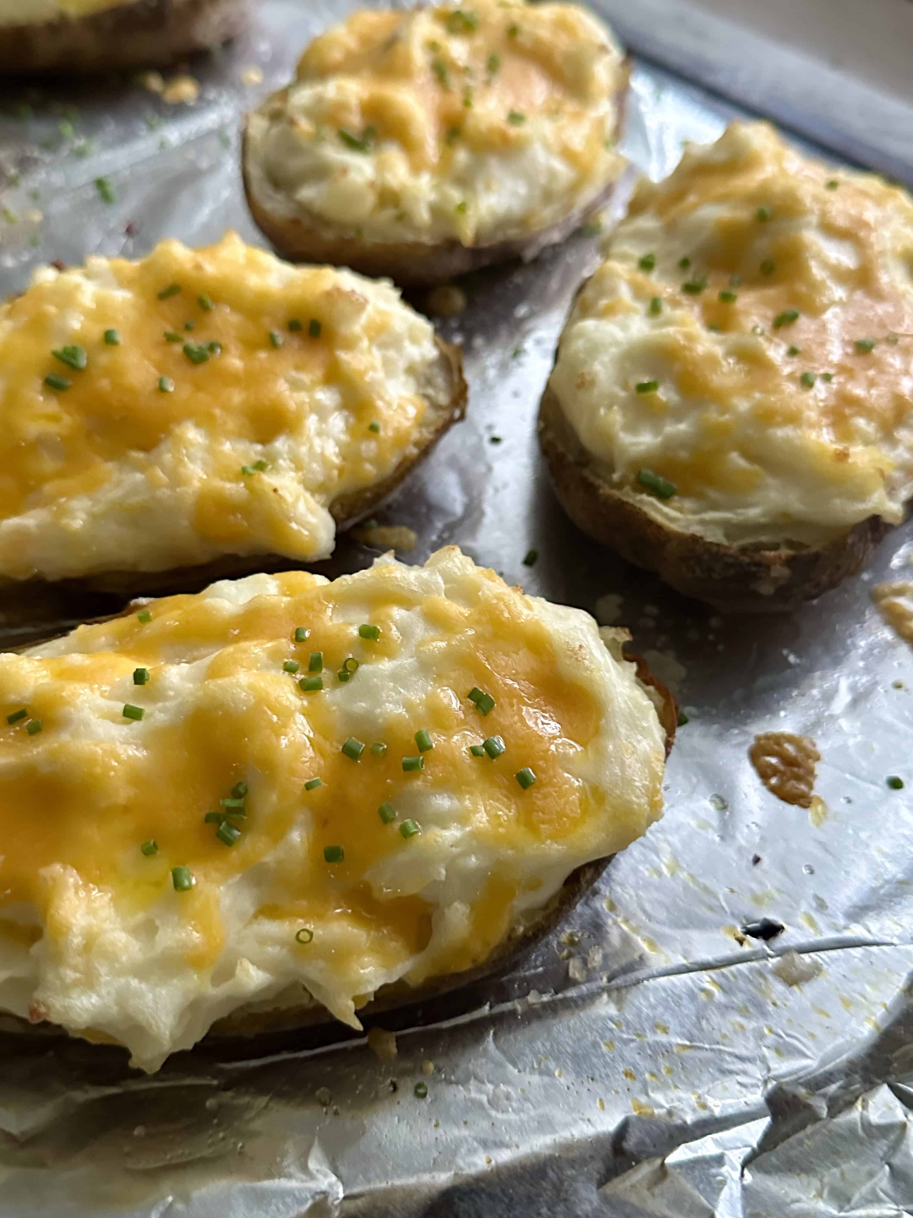 Twice baked potatoes on a foil lined baking pan. 