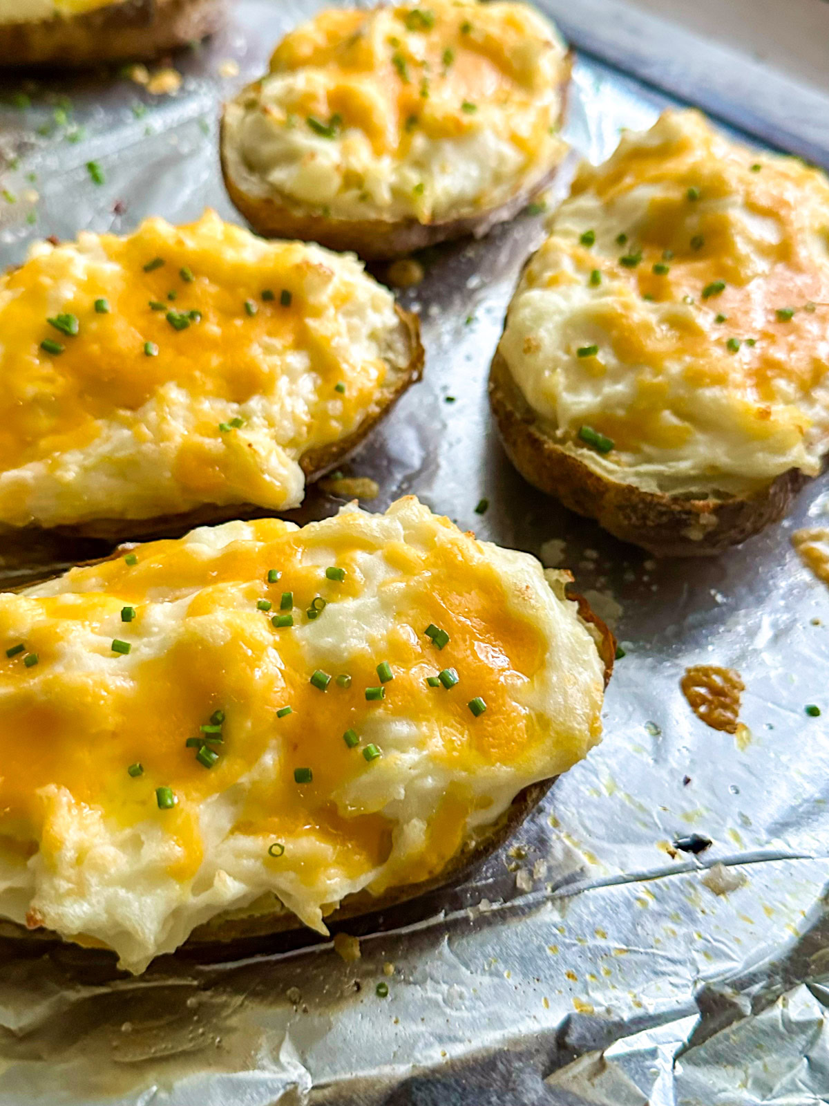 Twice baked potatoes on a foil lined baking pan. 