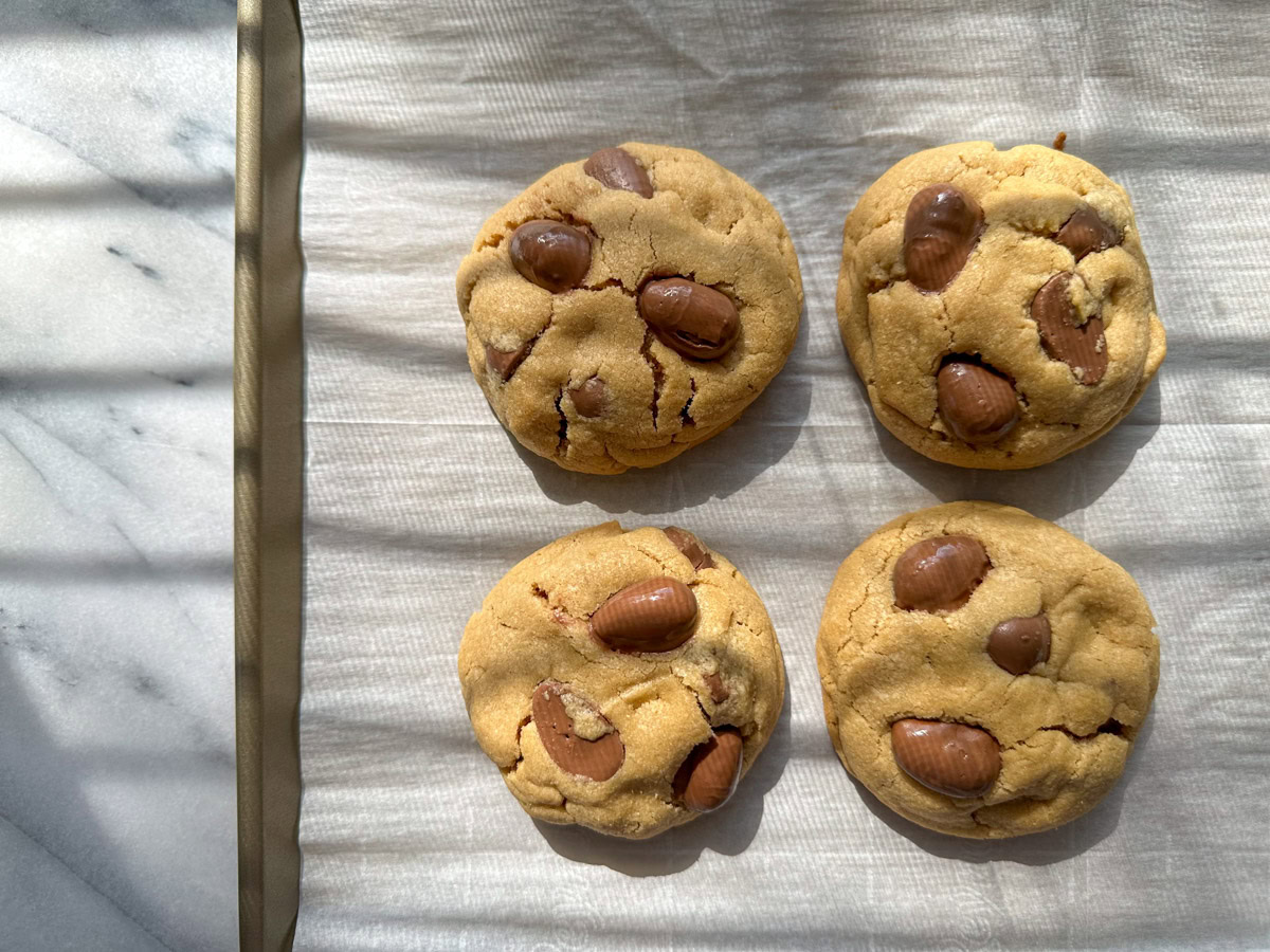 Reese's Egg Peanut Butter Cookies on a gold sheet tray.