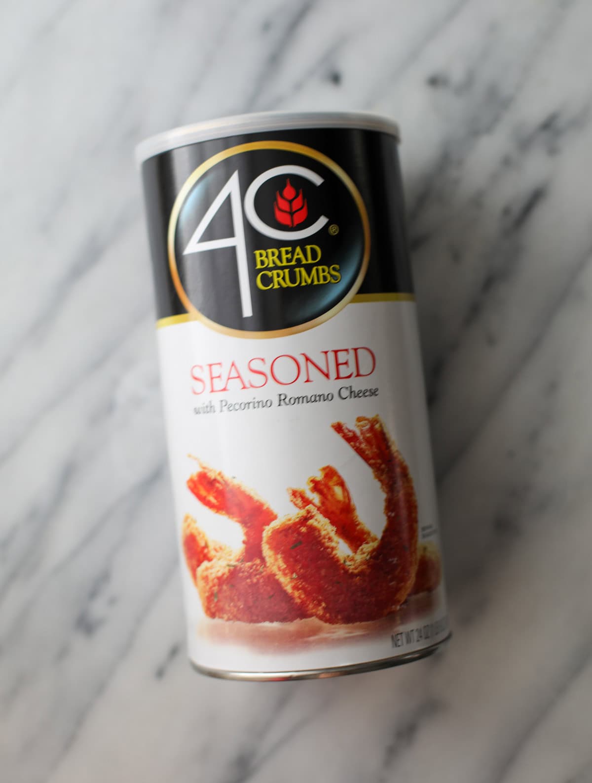 A container of 4C Italian seasoned breadcrumbs sitting on a marble counter.