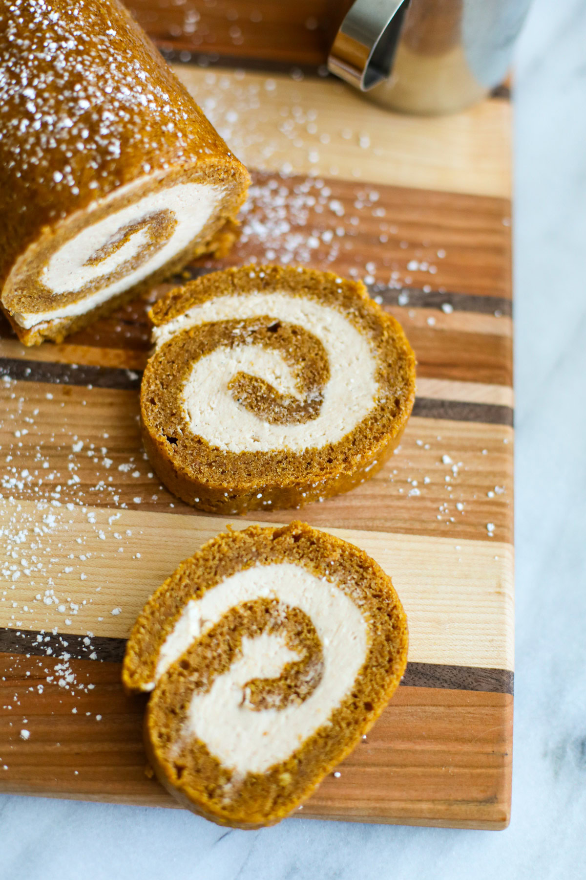 Two slices of pumpkin roll with a powdered sugar dusting.