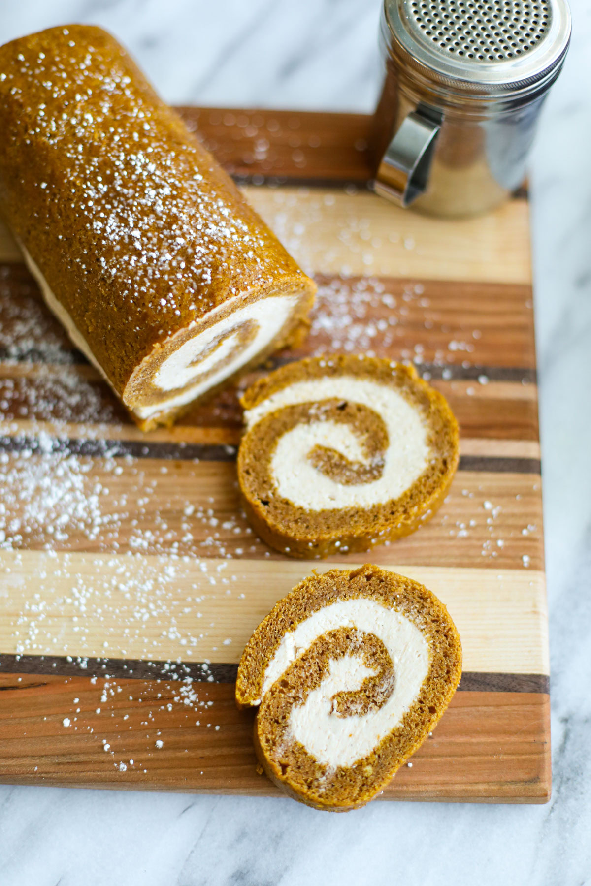 Two slices of pumpkin roll with a powdered sugar dusting.