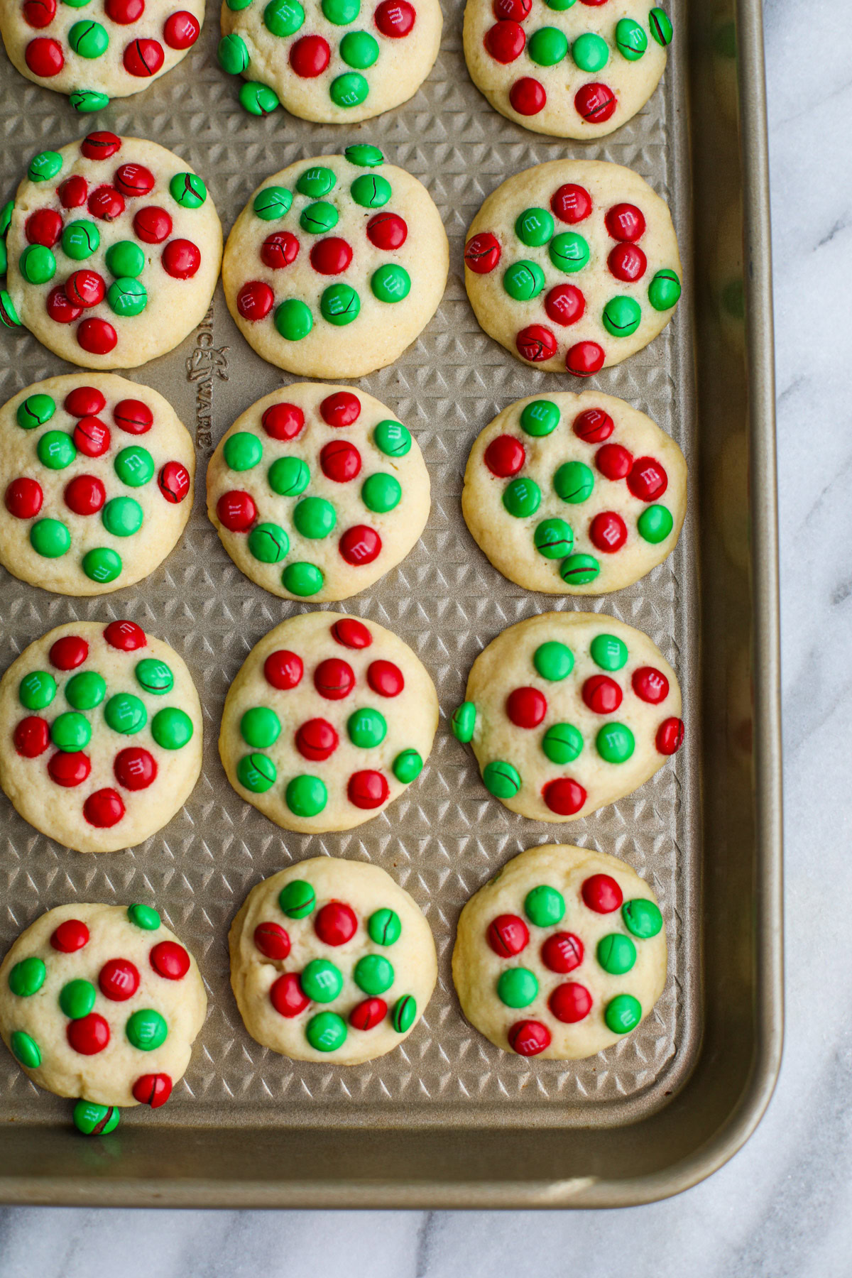 A gold sheet tray of red and green M&M butter cookies.