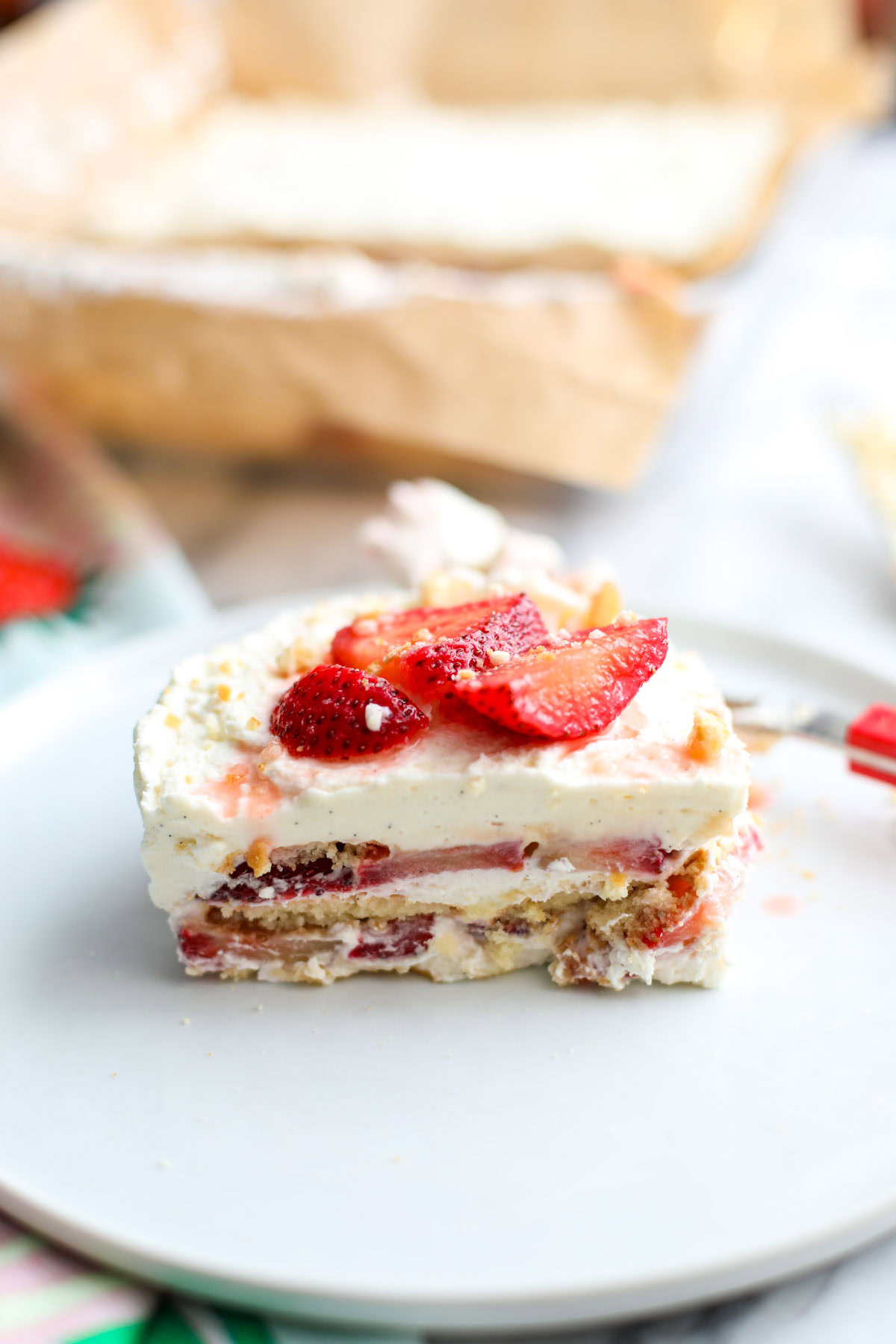 A slice of strawberry shortcake icebox cake on a white plate.