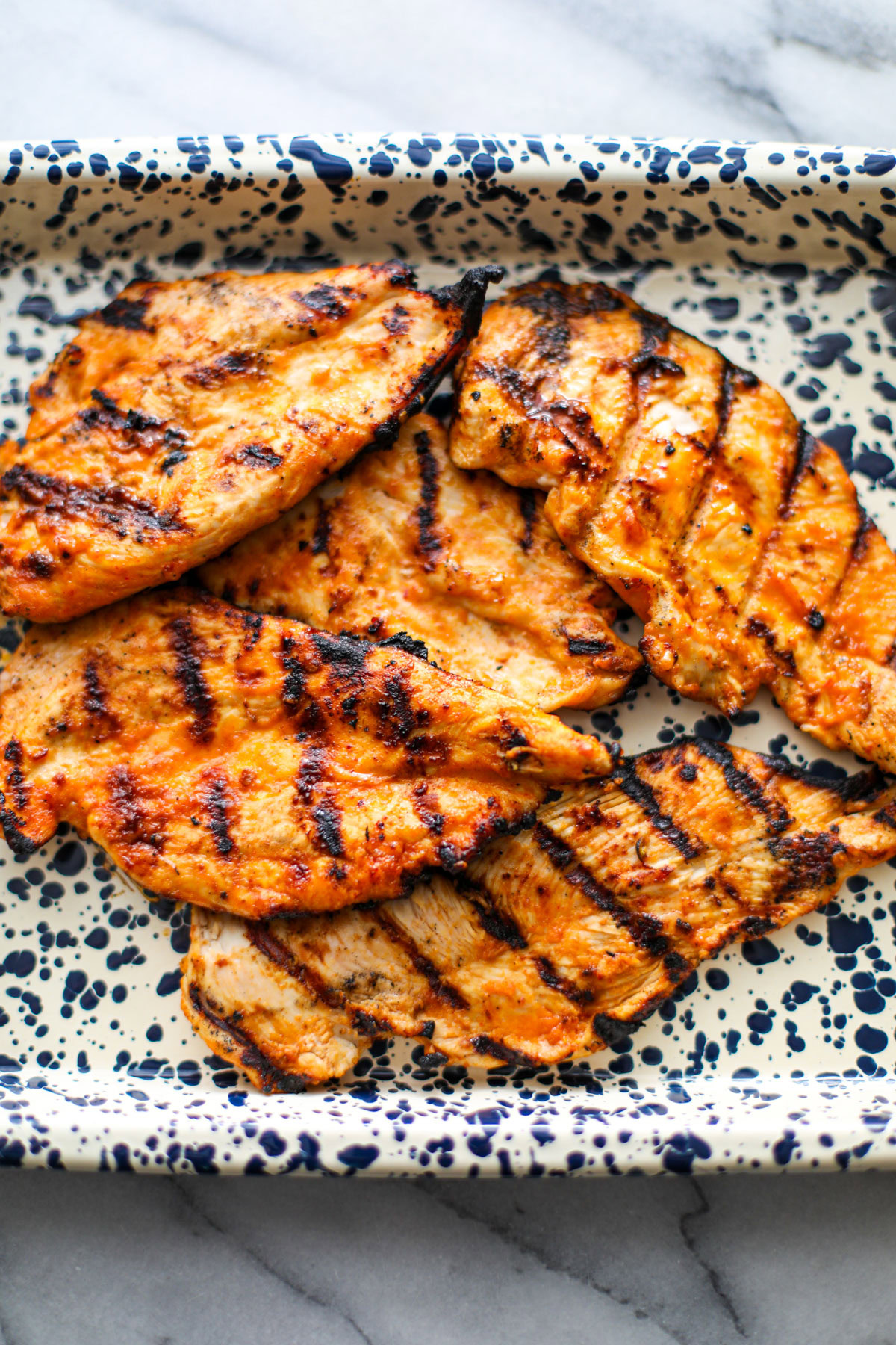 Grilled chicken on a spotted tray.