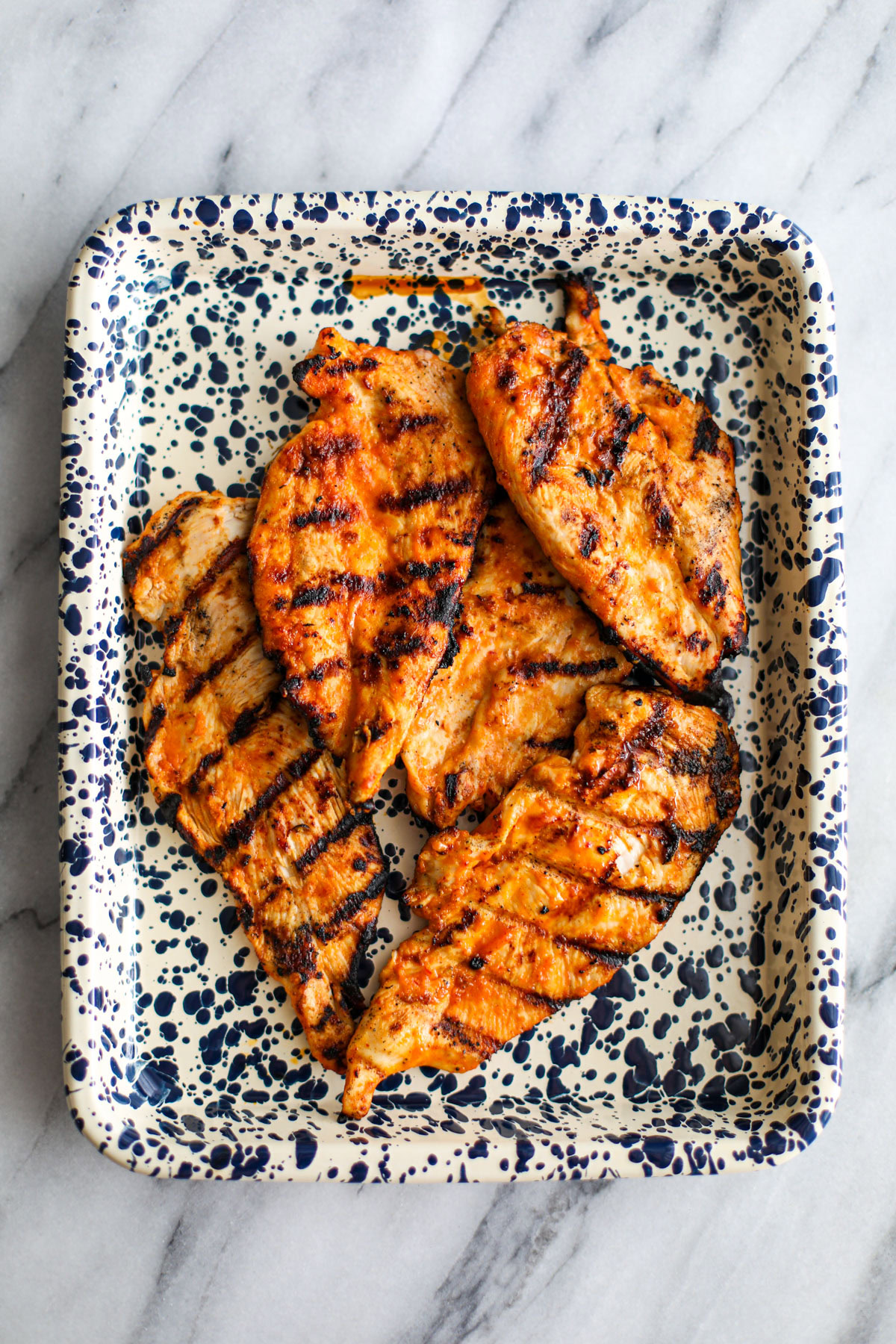 Grilled chicken on a spotted tray.