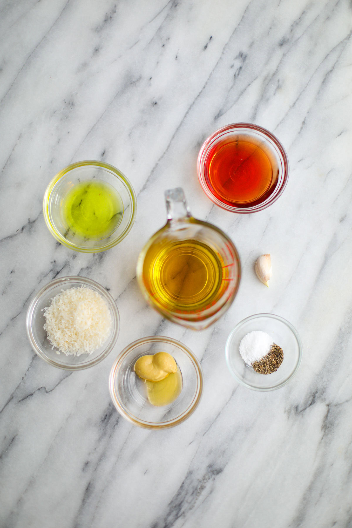 Bowls of honey, oil, vinegar, seasonings, mustard, and cheese to make the dressing.