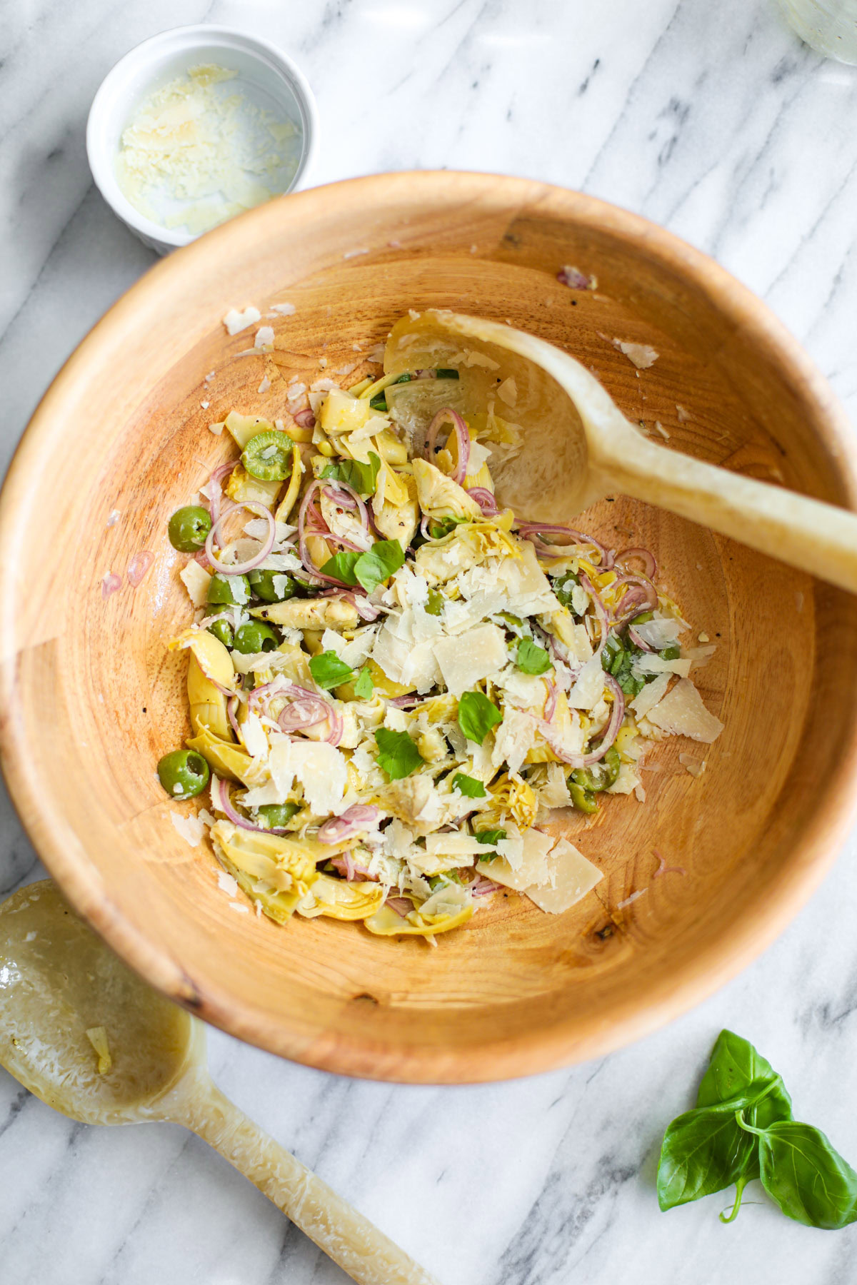 Artichoke Salad in a wood bowl with a serving spoon.