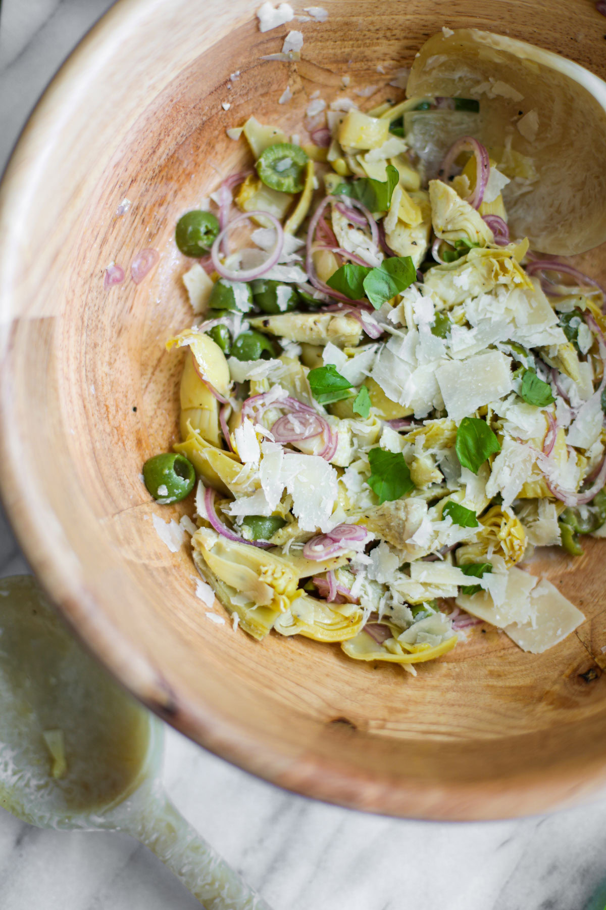 Artichoke Salad in a wood bowl with a serving spoon.