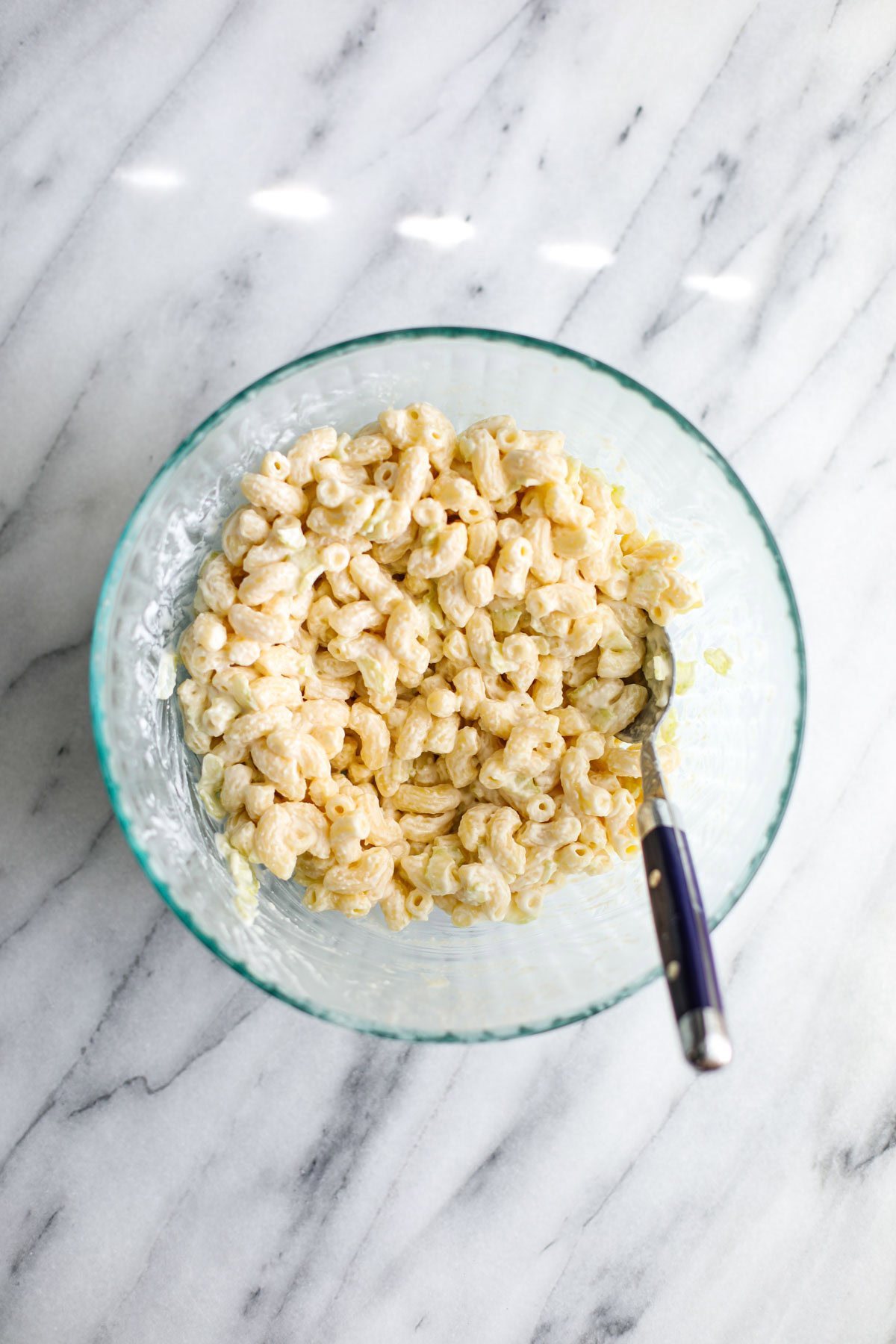 A glass bowl of deli macaroni salad.