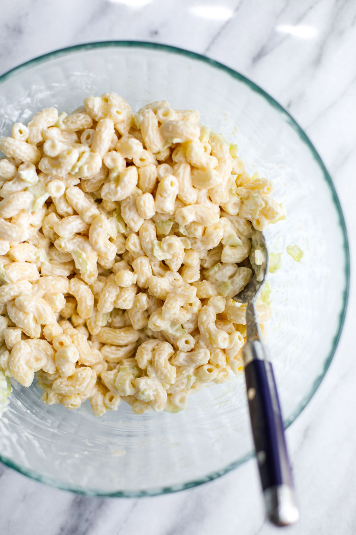 A glass bowl of deli macaroni salad.