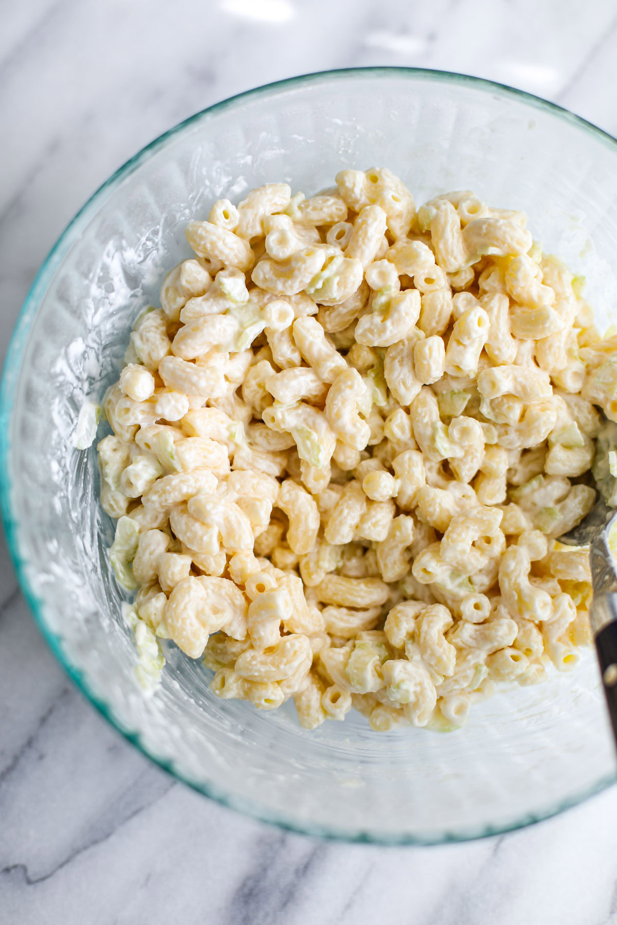 A glass bowl of deli macaroni salad.