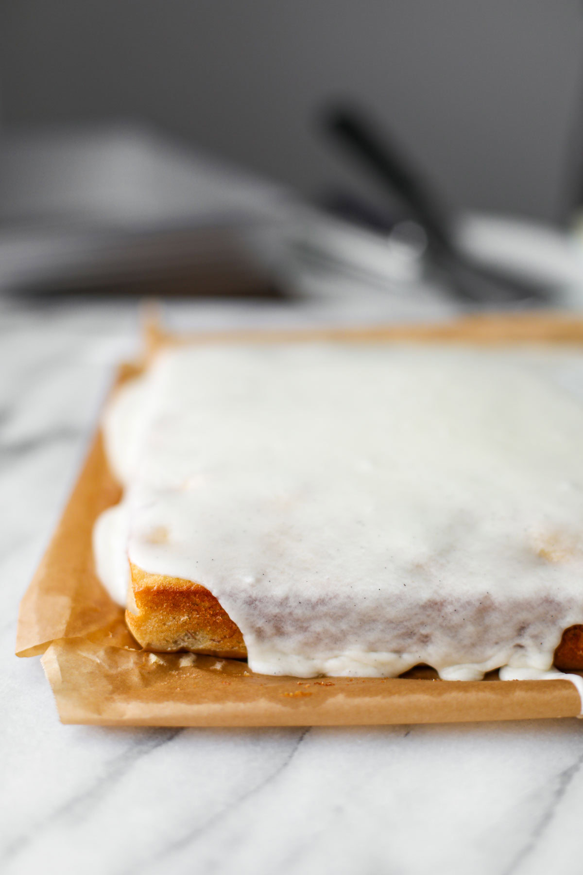 Frosted banana cake on parchment paper.