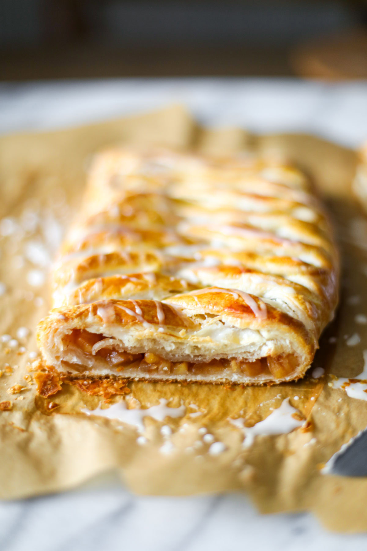 Apple danish cut open on parchment paper.
