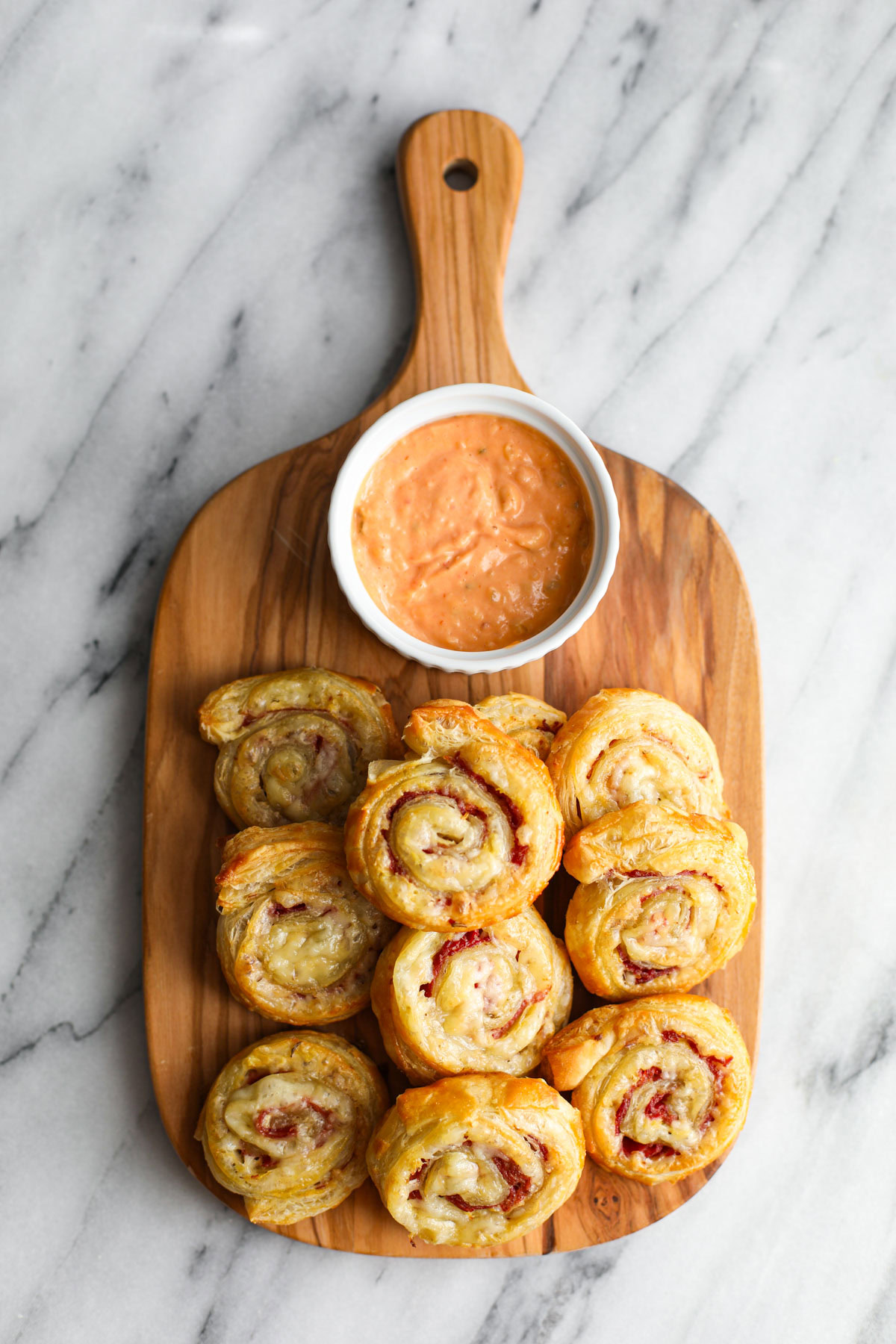A mound of pinwheels on a cutting board.