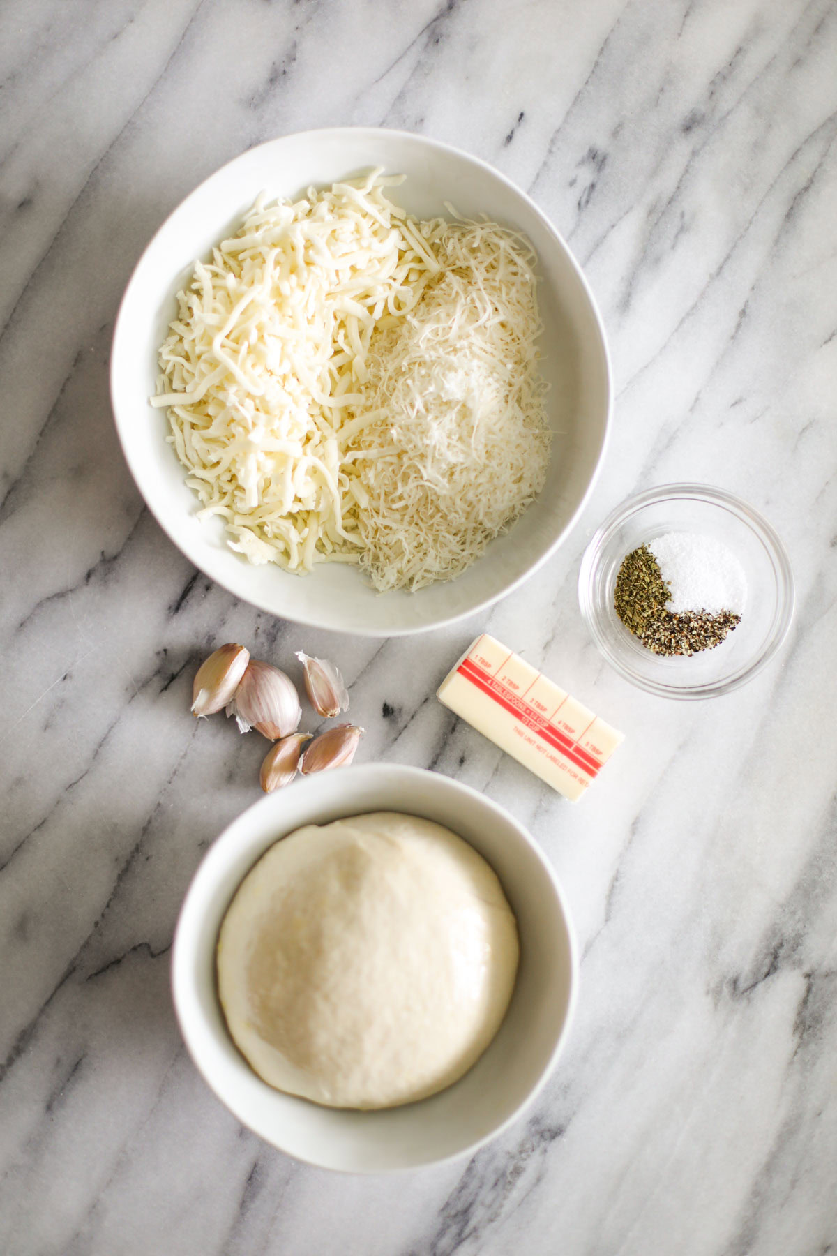 Ingredients for garlic pull apart loaf: pizza dough, mozzarella, Parmigiano Reggiano, butter, and garlic