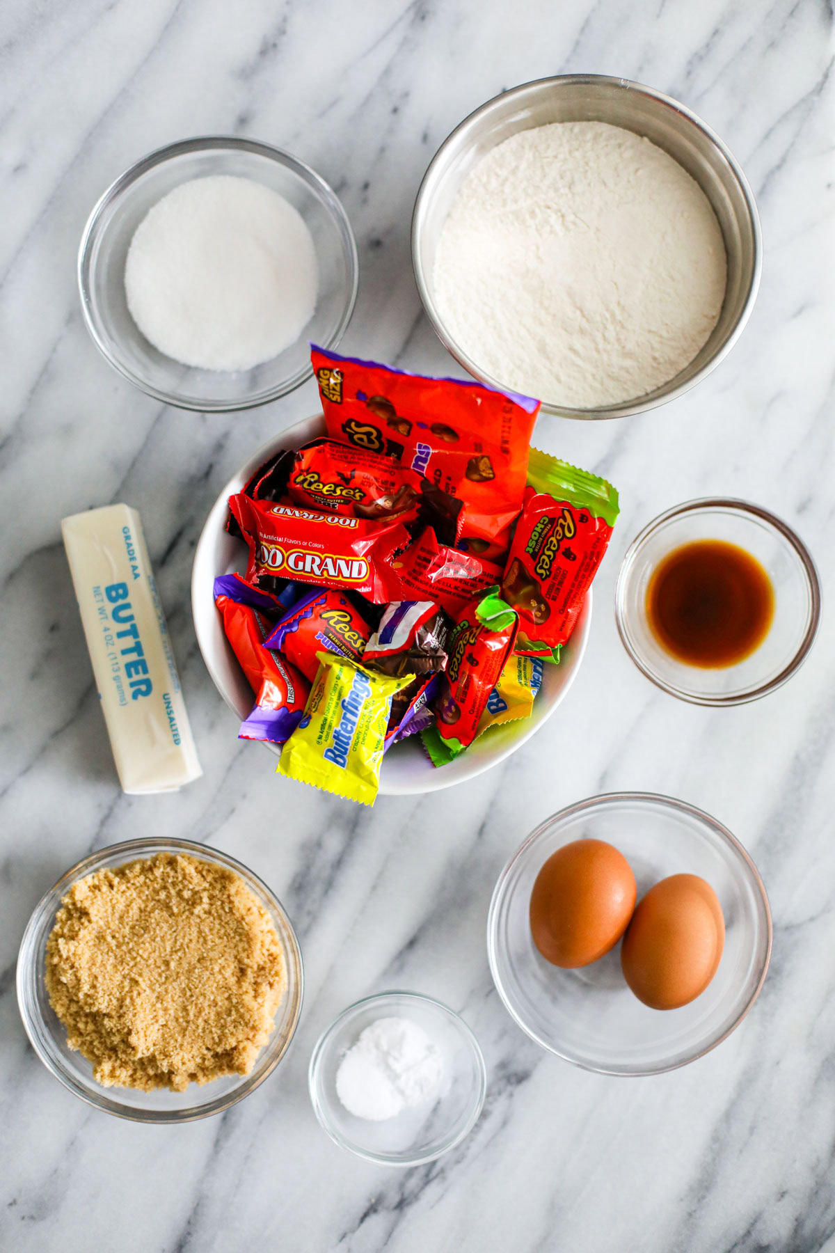 Ingredients for leftover Halloween candy cookie bars, including butter, brown sugar, eggs, flour, and chopped Halloween candy.