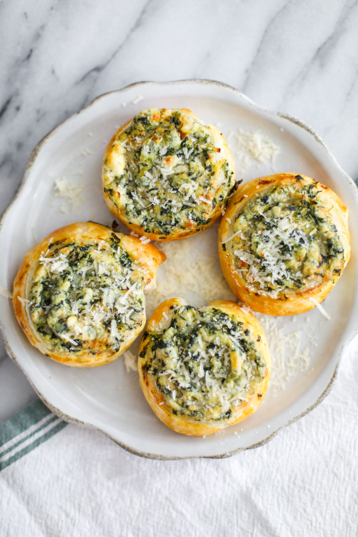 Spinach and artichoke pinwheels with a sprinkle of parmigiano reggiano.