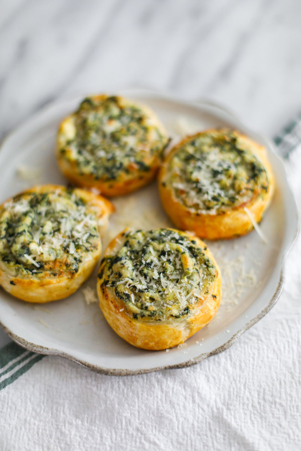 Spinach artichoke pinwheels on a serving platter.